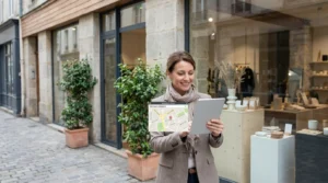 Entrepreneur français consultant les résultats de recherche locale sur sa tablette devant sa boutique